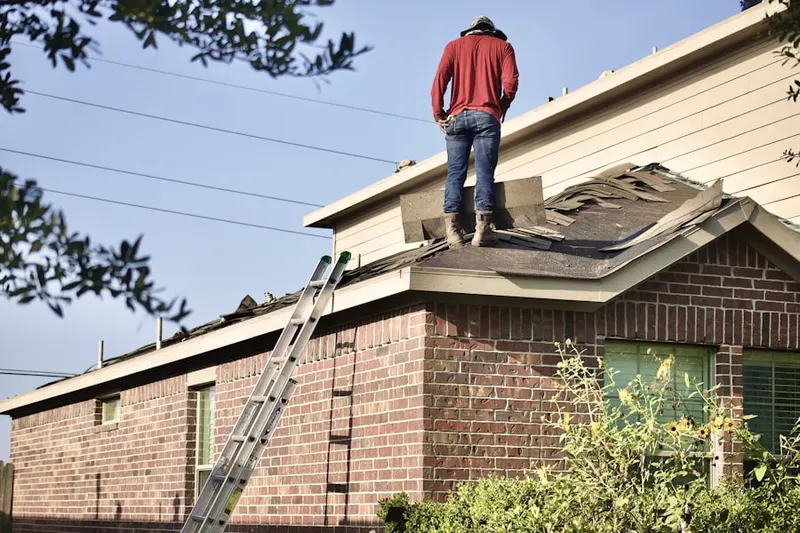 Professional roofer working on a residential roof in Heritage of Huntley